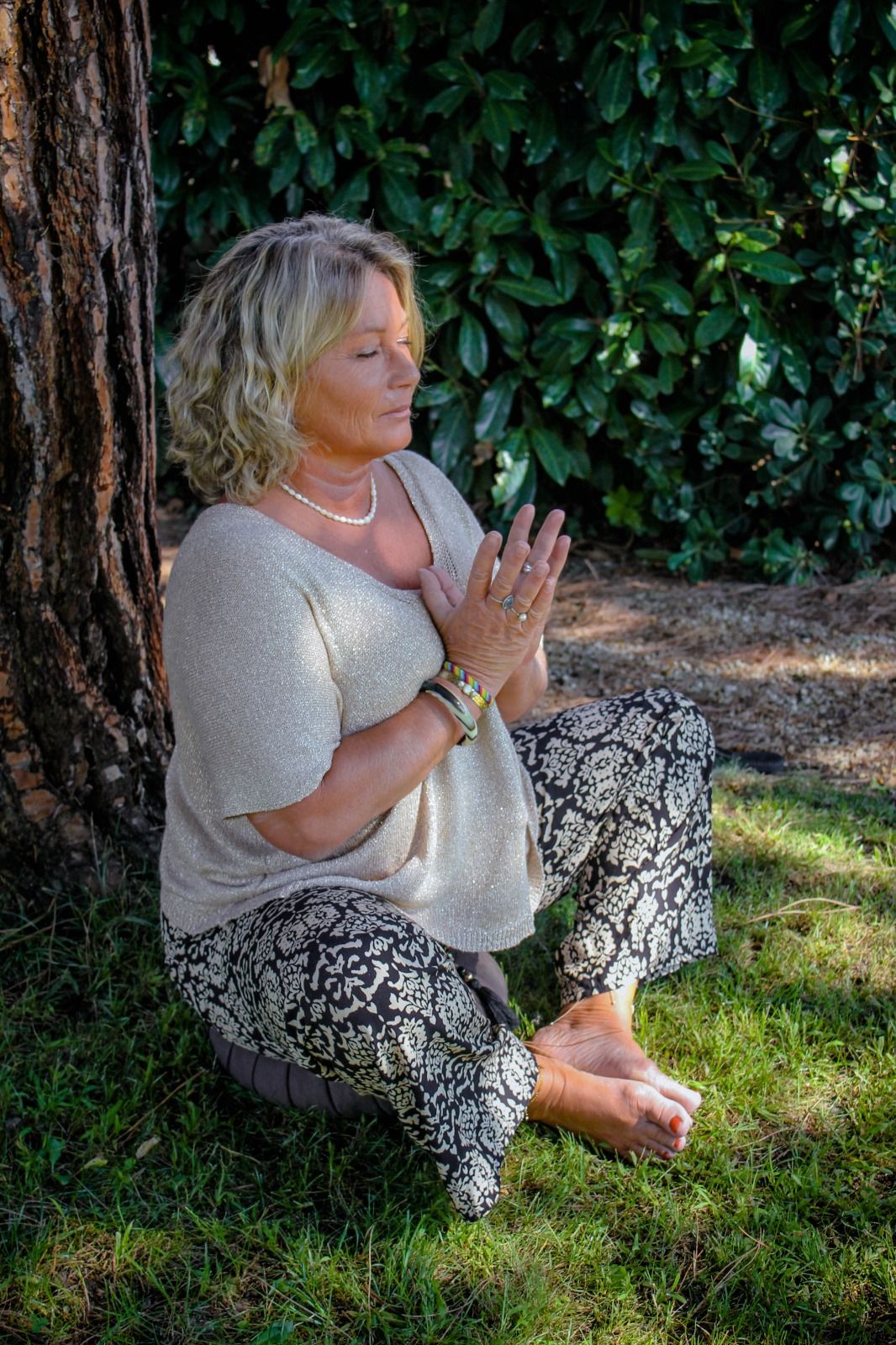 Marielle en méditation, assise dans l'herbe